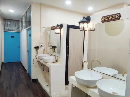 a bathroom with three sinks and two mirrors at Infinite Idol Home in Bangkok