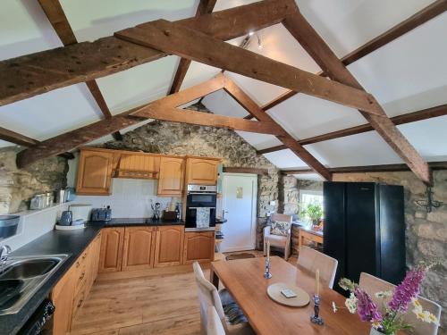 eine Küche mit Holzschränken und einem Holztisch in der Unterkunft The Old Vestry - pet friendly! in Manortown