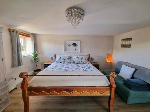 ein Schlafzimmer mit einem Bett und einer Couch in der Unterkunft The Old Vestry - pet friendly! in Manortown