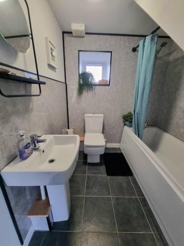 a bathroom with a sink and a toilet and a tub at The Old Vestry - pet friendly! in Manortown