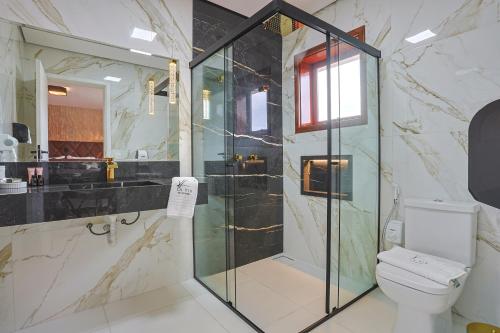 a bathroom with a shower and a toilet at La Vita Pousada de Charme in Campos do Jordão