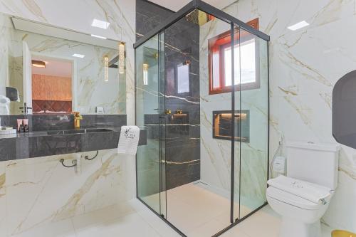 a bathroom with a shower and a toilet at La Vita Pousada de Charme in Campos do Jordão