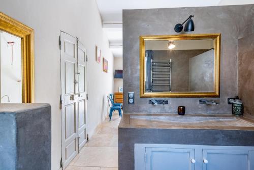 ein Badezimmer mit Waschbecken und Spiegel in der Unterkunft Bastide Aubignan in Aubignan