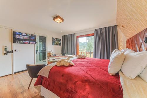 a bedroom with a large red bed and a desk at La Vita Pousada de Charme in Campos do Jordão