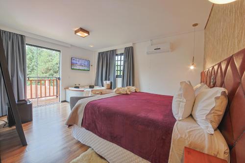 a hotel room with a bed and a bathroom at La Vita Pousada de Charme in Campos do Jordão
