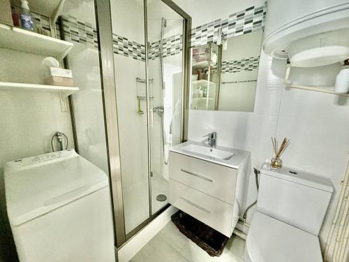 une salle de bain blanche avec un lavabo et des toilettes dans l'établissement Appartement climatisé à 700m de la plage avec garage - FR-1-816-20, à Bormes-les-Mimosas