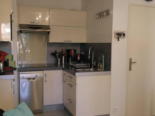 une cuisine avec un évier et une cuisinière four supérieur dans l'établissement Appartement climatisé à 700m de la plage avec garage - FR-1-816-20, à Bormes-les-Mimosas