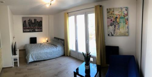 a bedroom with a bed and a large window at Studio with terrace in Saint-Denis