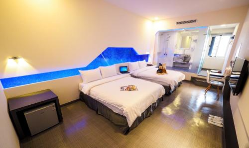 Schlafzimmer mit einem großen Bett mit blauem Kopfteil in der Unterkunft Galaxia Business Hotel in Taichung