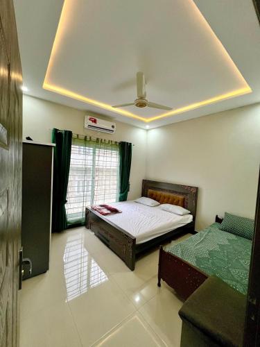 a bedroom with a bed and a ceiling at Home Abroad Guest House in Thathāl