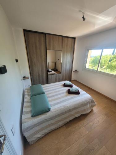 une chambre avec un grand lit avec une grande fenêtre dans l'établissement Le mas Les Salamandres, à Lorgues