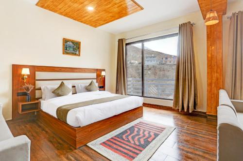 a bedroom with a bed and a large window at Utpala House By Lifestyle Stays in Sissu