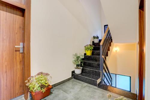 a staircase in a house with potted plants at Utpala House By Lifestyle Stays in Sissu