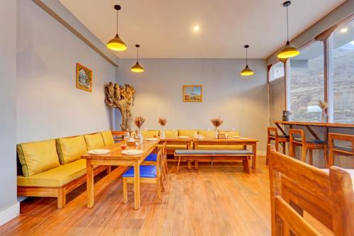 a living room with a yellow couch and a table at Utpala House By Lifestyle Stays in Sissu