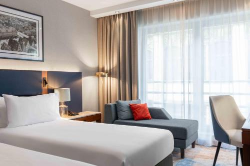 a hotel room with a bed and a chair at Wyndham Wroclaw Old Town in Wrocław