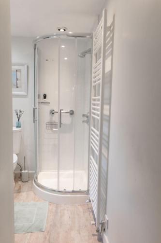 a shower with a glass door in a bathroom at Honeysuckle Cottage Newton Ferrers in Newton Ferrers