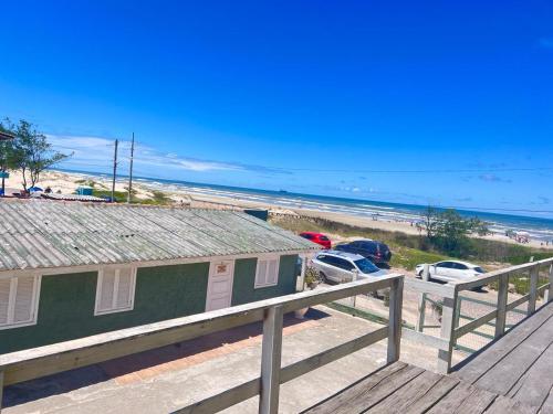 a view of a beach with cars parked next to a house at Pousada Brisa do Mar in Tramandaí