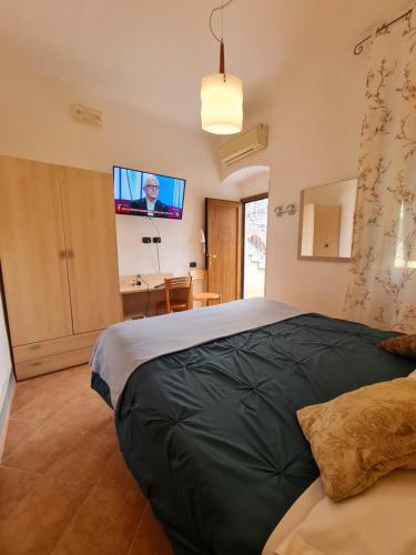 a bedroom with a bed with a tv on the wall at Albergo Genio in Portovenere