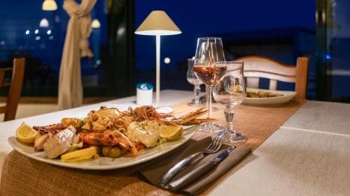 a plate of seafood on a table with wine glasses at Centro Turistico San Nicola in Peschici