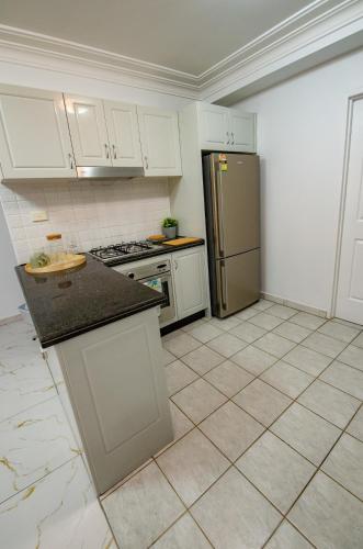 a kitchen with white cabinets and a stainless steel refrigerator at 2Bedrooms, 2-bath, 1 Garage Apartment in Sydney
