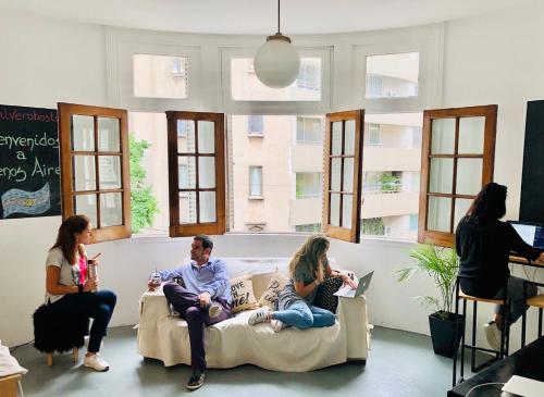 un grupo de personas sentadas en un sofá en una habitación en ilVero Hostel Recoleta, en Buenos Aires