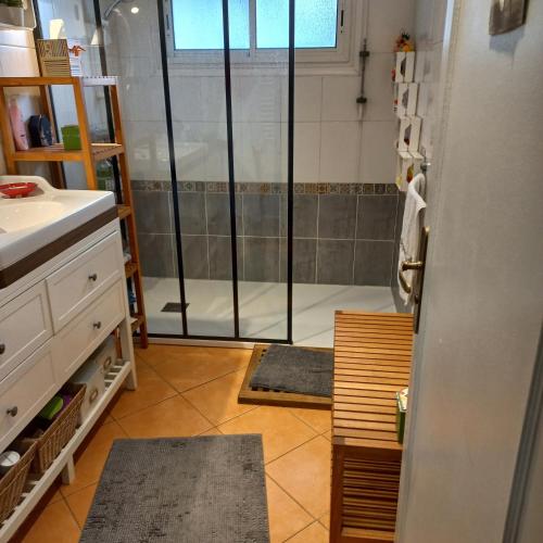 une salle de bain avec une douche avec une porte vitrée dans l'établissement Ty Clafout, à Saint-Nolff