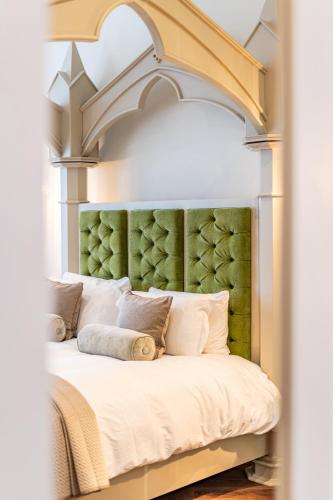 a bedroom with a large bed with a green headboard at St Marys Quarters in Nottingham