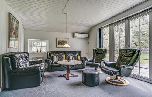 a living room with chairs and a table and windows at Holiday Home Nørballevej Blåvand I in Ho