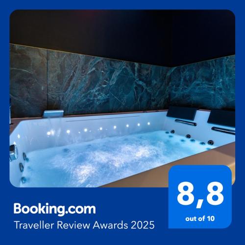 La salle de bains est pourvue d'une baignoire et d'un mur en pierre. dans l'établissement Love Room Pour un séjour en amoureux, à Sotteville-lès-Rouen