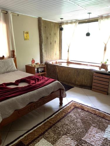 une chambre avec un lit et une baignoire dans l'établissement Chalé Imperial, à Santa Leopoldina