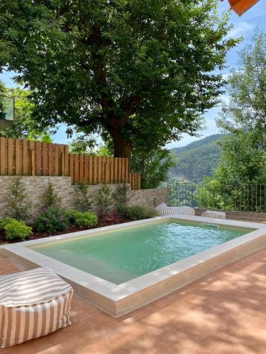 a swimming pool in a backyard with a tree at Refúgio da Caniçada - T4, Piscina Aquecida (Gerês) in Geres