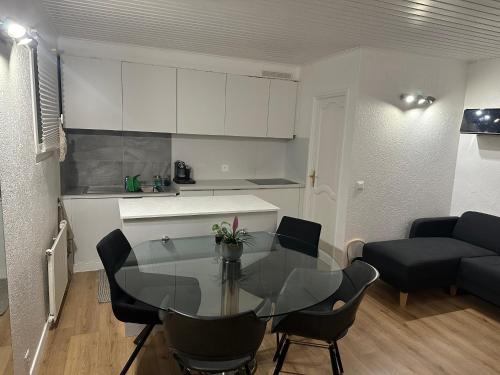 una cucina e una sala da pranzo con tavolo in vetro di Les terrasses de Valère a Sion