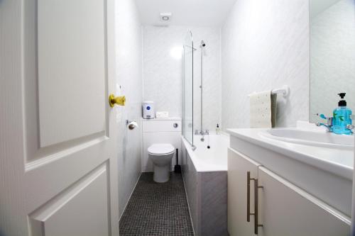 a white bathroom with a sink and a toilet at Allerdale in Torquay