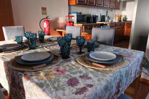 a table with blue vases and plates on it at Fun and Fly House in Praia da Vitória