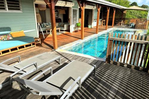 a deck with chairs and a swimming pool at Villa Acoma Lodge in Grand-Bourg