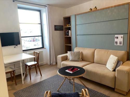 un salon avec un canapé et une table dans l'établissement Studio moderne au cœur de Sauzon avec kitchenette et Wi-Fi - FR-1-418-227, à Sauzon