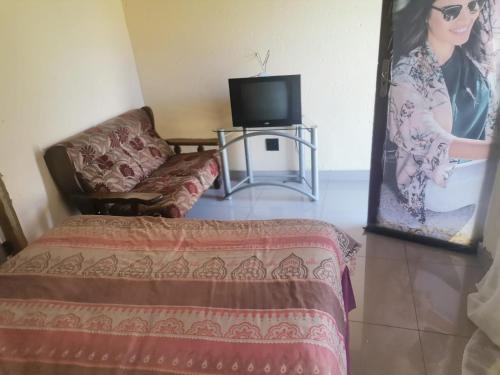 a living room with a couch and a television at Jamrock Lodge in Winterveld