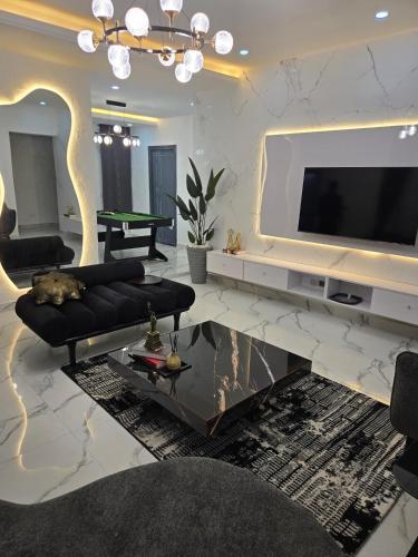 a living room with a television and a couch and a table at Nestshield Apartments in Abuja