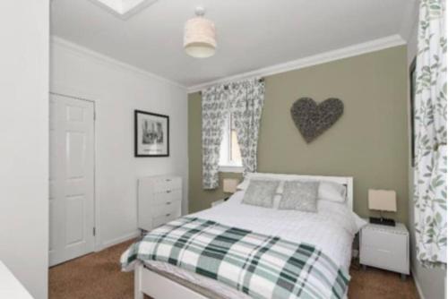 a bedroom with a bed and a heart on the wall at Grangeburn Residence - 2 bedroom home with parking in Falkirk