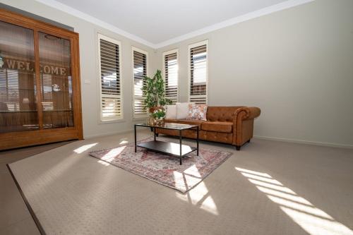 una sala de estar con un sofá y una mesa en Entire 4 Bed Rooms Sanctuary, en West Hoxton