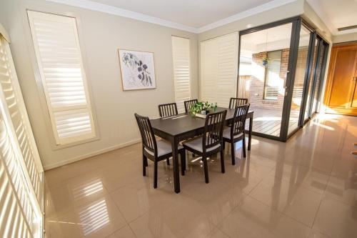 Un comedor con mesa y sillas en Entire 4 Bed Rooms Sanctuary, en West Hoxton
