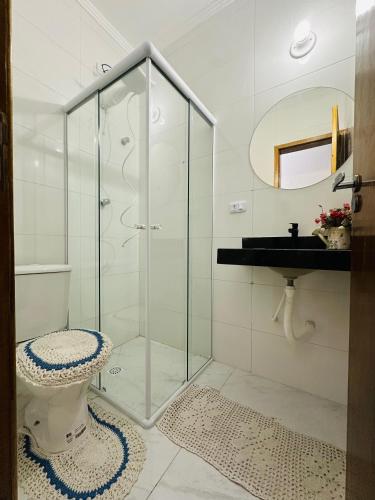 a bathroom with a shower and a toilet and a sink at LAAR Hotel in Praia Grande