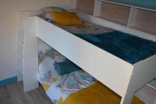 Ce lit superposé se trouve dans un dortoir doté d'un lit blanc. dans l'établissement Chez Boucharet, à Ceyssat