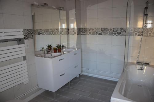 une salle de bain blanche avec un lavabo et une douche dans l'établissement Chez Boucharet, à Ceyssat