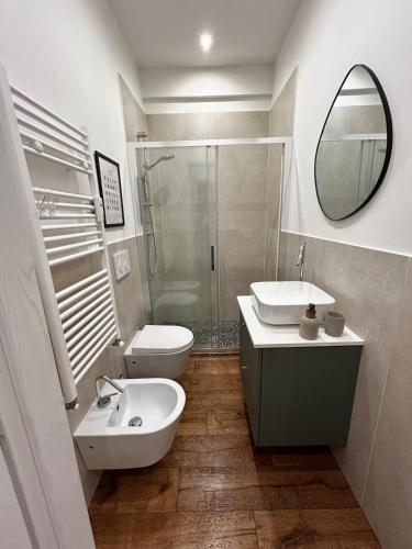 ein Badezimmer mit Waschbecken, Toilette und Spiegel in der Unterkunft Magnolia 84 Apartment in Florenz