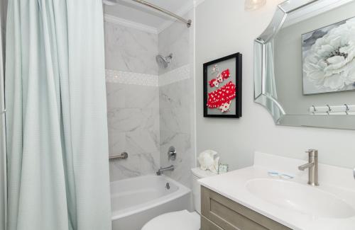 e bagno bianco con doccia, servizi igienici e lavandino. di Bianchi by Braynt Real Estate a Kure Beach