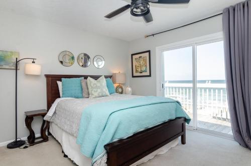 una camera da letto con un letto e una grande finestra di Bianchi by Braynt Real Estate a Kure Beach