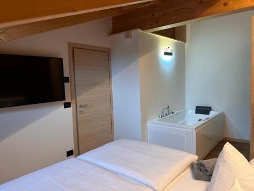 a white bedroom with a bed and a sink at Casa Franz in Tesero