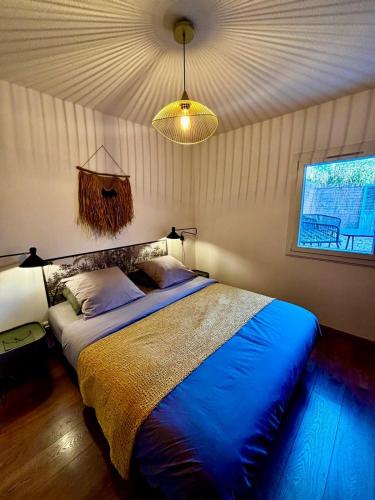 une chambre avec un grand lit avec une couverture bleue dans l'établissement Appart Standing, Jardin, Terrasse, Parking, à Montpellier