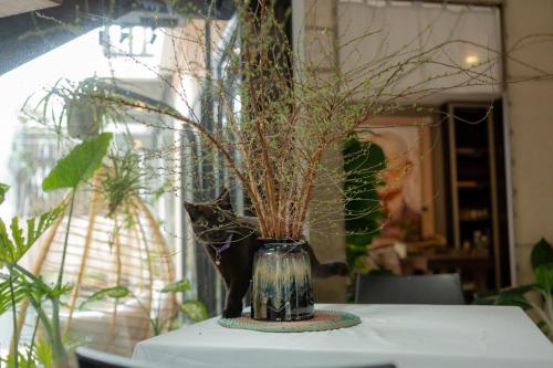 a vase with plants in it sitting on a table at Du De Homestay in Hoi An